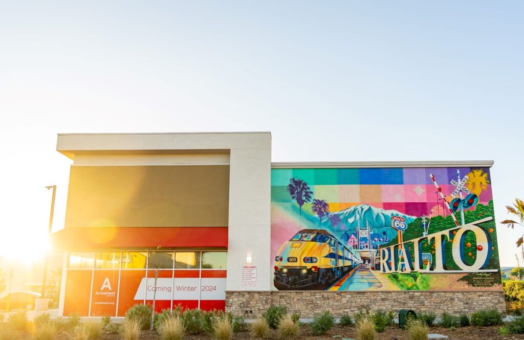 Arrowhead and mural of train and route 66 with mountain image at Rialto Village
