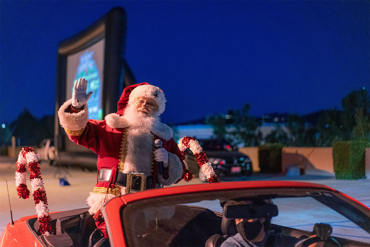 Santa Claus waving from sunroof of a car