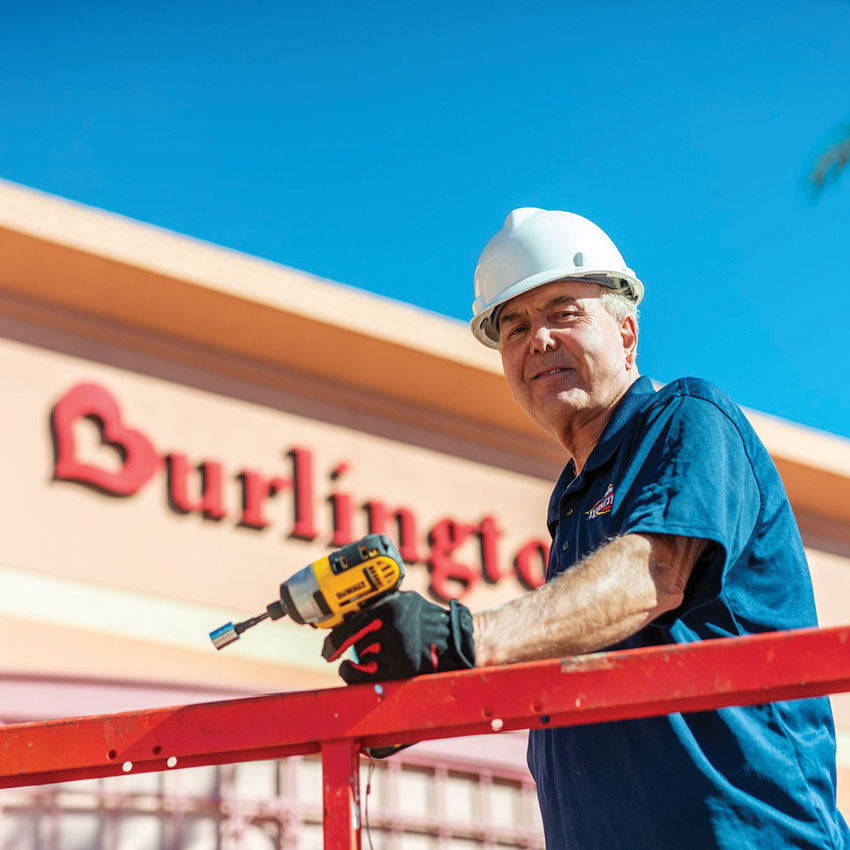 Man with drill doing maintenance on shopping center