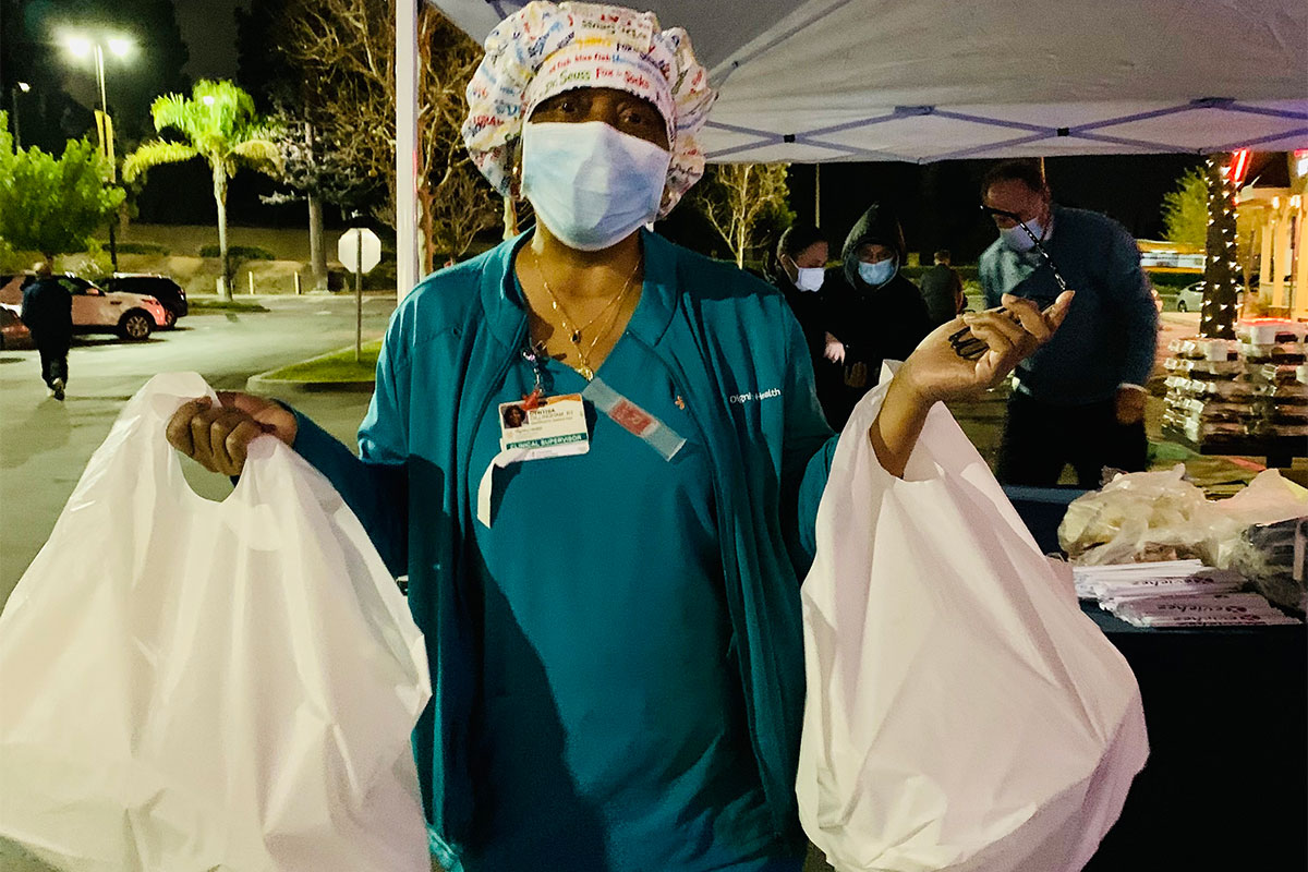 Medical worker carrying bags of groceries